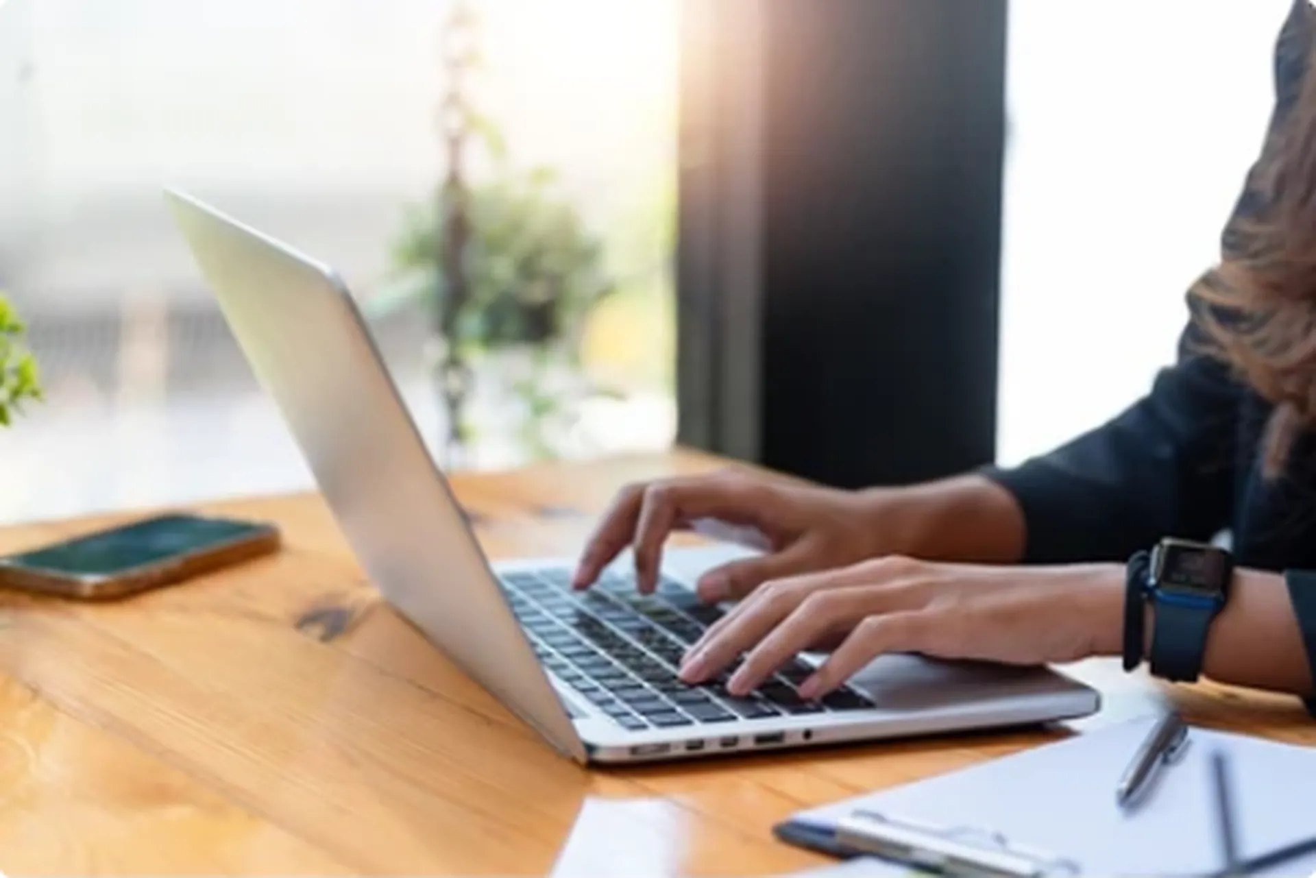 Jak przygotować materiały do strony internetowej? Brief, teksty i zdjęcia krok po kroku Osoba pracująca na laptopie przy biurku w jasnym, naturalnym oświetleniu